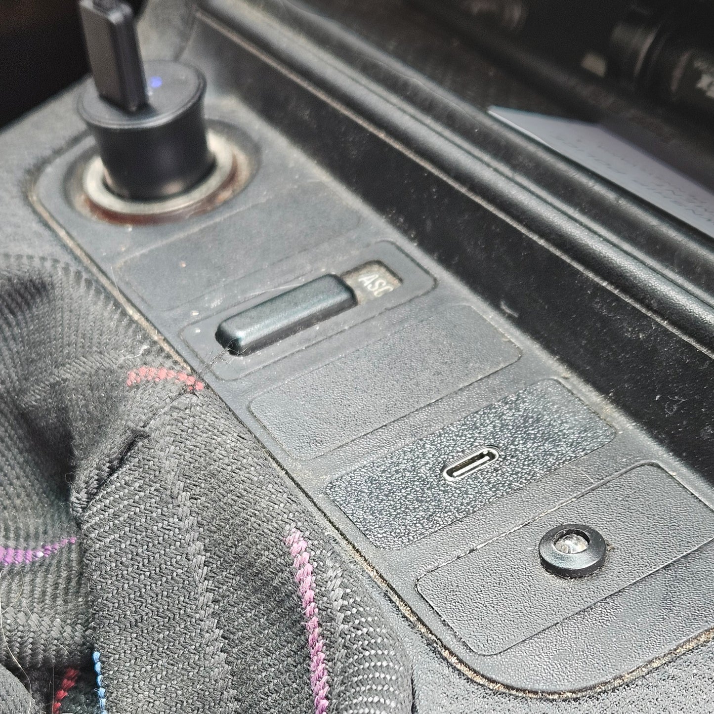 Close-up of a car's USB charging port with a cable plugged in.